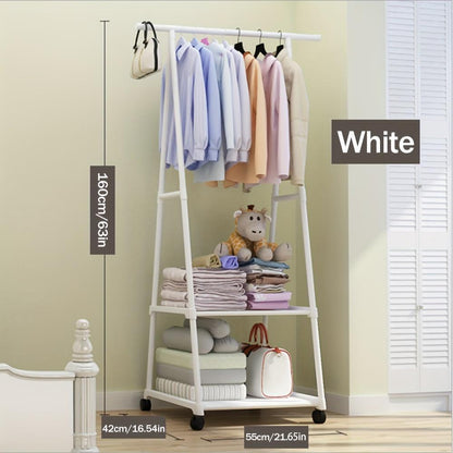 White clothing rack with clothes and toys against a light green wall.