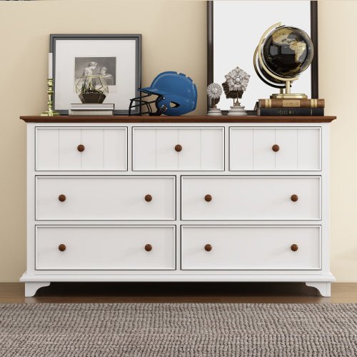 White dresser with wooden top against a beige wall with decorative items.