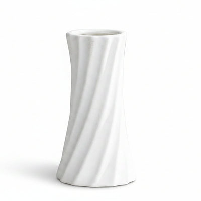 A white ceramic vase with a twisted, fluted design, shown on a light gray surface with text overlay detailing its dimensions.