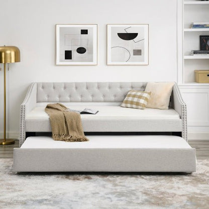 Gray upholstered bed with a pull-out trundle in a modern bedroom setting.